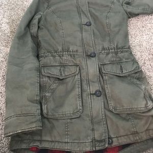 a green jacket with a hood very worm and comfy